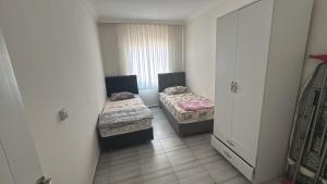 een kleine kamer met 2 bedden en een kast bij Köşk Rezidans 