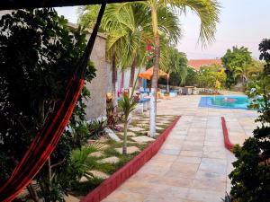 a resort with a hammock by a swimming pool at Flat da Claudia canoaQUEBRADA in Canoa Quebrada +12 photos