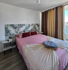 圣地亚哥Atardecer Santiago的卧室里有一张大床，床上铺着一条紫色毯子。