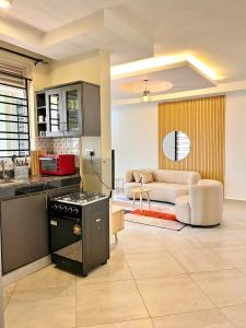 a kitchen and living room with a stove and a couch at Apartment unit-Luxury in Kampala