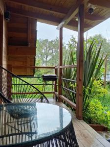 a patio with a glass table and chairs on a deck at Cabañas el tigre in Mazamitla