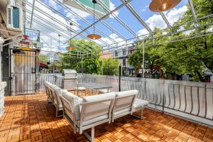 a patio with white chairs and a glass roof at Theatre Hotel by Lodgo in Montréal