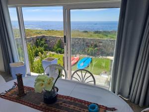 a room with a large window looking out at the ocean at 23 On Beach in Stompneusbaai