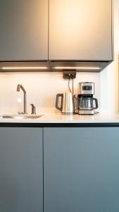 a kitchen counter with a sink and a microwave at Karlatornet Sky Level in Gothenburg +65 photos