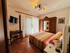 维罗纳Residenza Fontana del Ferro的一间卧室，里面有一张床、一张桌子和一台电视。