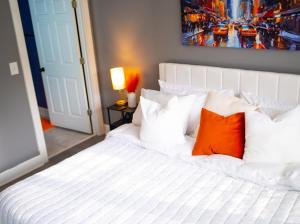 a white bed with orange pillows in a bedroom at The Blue Oasis in Charlotte