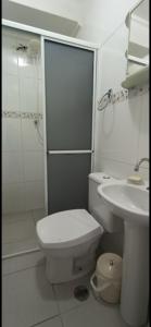 a white bathroom with a toilet and a sink at Apartamento 2 suítes Pitangueiras Guarujá in Guarujá +16 photos