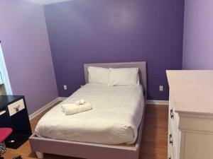a purple bedroom with a bed with two towels on it at Lovely 3 Bed 2 ba Townhome in Saint Peter