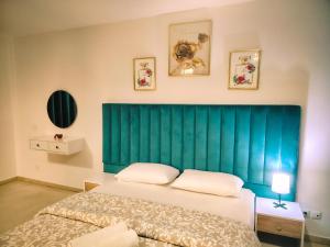 a bedroom with a green headboard and a bed at Perfect Appartement a Malabata au plein centre ville en face Hilton & la Gare de Train TGV N3 in Tangier