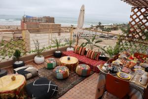 Un patio con mesa y sillas y la playa. en Anza Surf Experience Hostel, en Agadir