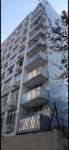 a tall apartment building with balconies on it at Apartamento 2 suítes Pitangueiras Guarujá in Guarujá