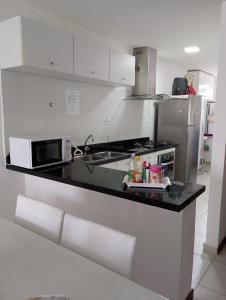 a kitchen with a counter with a microwave and a stove at Apartamento em Subaúma no Resort Tree Bies in Entre Rios +29 photos