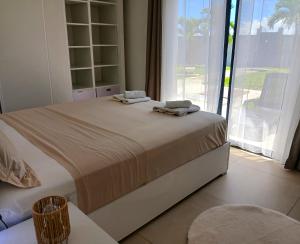 a bed in a room with a large window at B&B chez Momo in Sainte-Anne