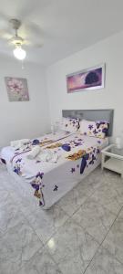 a bedroom with a bed with a floral bedspread at IRIS HOME POOL and GARDEN in Benalmádena