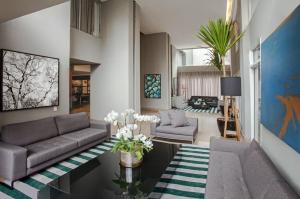 a living room with a couch and a table at Flat Wyndham2 Paulista com estacionamento in Sao Paulo