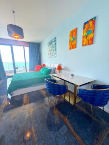 a bedroom with a bed and a table and chairs at Bamboo Beach Tsikhisdziri Seaview Flat 839 in Tsikhisdziri