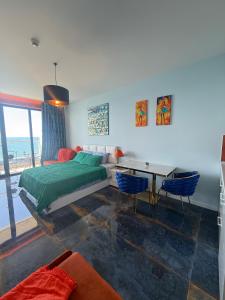 a bedroom with a bed and a table with chairs at Bamboo Beach Tsikhisdziri Seaview Flat 839 in Tsikhisdziri