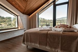 a bedroom with a bed with a large window at Dzvin in Slavske