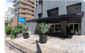 a building with potted plants in front of it at Flat Wyndham2 Paulista com estacionamento in Sao Paulo