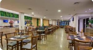 a restaurant with wooden tables and chairs and a bar at Flat Wyndham2 Paulista com estacionamento in Sao Paulo