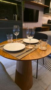 un tavolo di legno con bicchieri e piatti di Dani Studio Moema Grand Vitrali a San Paolo Altre 43 foto