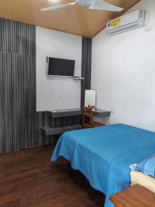 a room with a bed and a flat screen tv at Cabinas Popular in Puerto Viejo