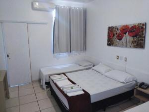 a bedroom with a bed and a window with red flowers at igu falls in Foz do Iguaçu