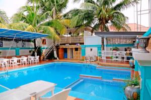 a large swimming pool with palm trees in the background at 5 Star Villa Hotel in Accra
