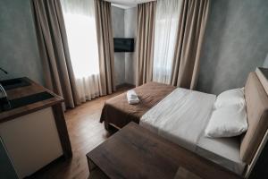 Habitación pequeña con cama y ventana en Апарт отель NOMERA, en Uralsk