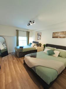 two beds in a room with wooden floors at Luxury 2 Bedroom Apartment in Old Town Swindon in Swindon +35 photos