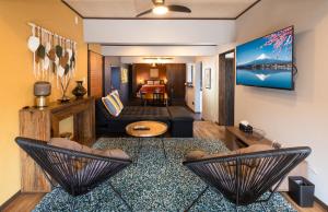 a living room with two chairs and a couch at Mimitsu Lounge CASAKURA in Hyuga