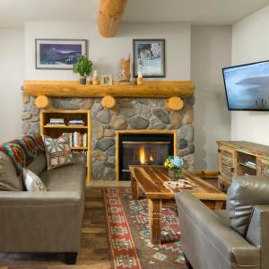 a living room with a stone fireplace at The Bivvi Hostel in Breckenridge