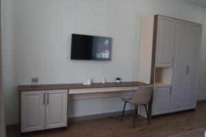 a room with a desk with a television on a wall at Апарт-отель NOMERA in Oral