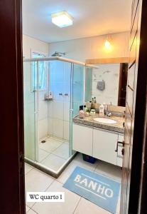 a bathroom with a glass shower and a sink at Casa de Praia em Carneiros in Tamandaré
