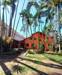 an orange house with palm trees in front of it at Quarto Familia prox ao centro Paraty in Paraty +20 photos