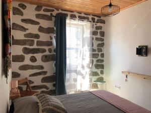 a bedroom with a window with a stone wall at Xaminé in Água Retorta +31 photos