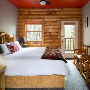 1 dormitorio con 1 cama grande y paredes de madera en The Bivvi Hostel, en Breckenridge