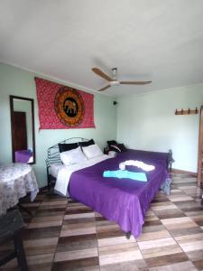 - une chambre avec un grand lit et une couette violette dans l'établissement Refugio de mar, à Costa Azul