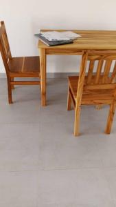 a wooden table and a chair sitting next to a table at Miramont Club Villas in Nungwi