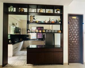 a kitchen with a wooden door and a counter with items at Aarudhra villa in Chennai
