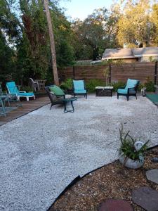 a patio with several chairs and a table and benches at Tropical Hideaway in Daytona Beach