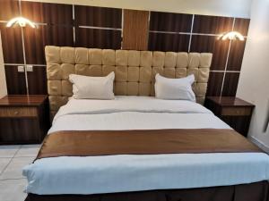 a bedroom with a large bed with two night stands at شقق شذا للشقق المخدومة-درجة التصنيف-اقتصادي in Jeddah