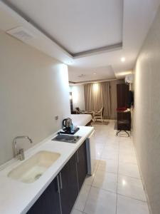 a kitchen with a sink and a living room at شقق شذا للشقق المخدومة-درجة التصنيف-اقتصادي in Jeddah