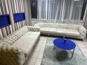 a living room with two couches and a blue table at Ankara Kızılay konaklama in Ankara