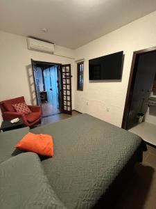 a bedroom with a bed and a tv on the wall at The Gallery Floripa in Florianópolis