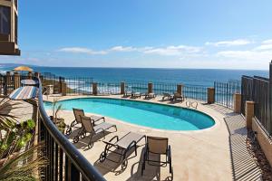 a swimming pool with chairs and the ocean in the background at Sea Forever - DMST3536 in Solana Beach