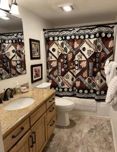 a bathroom with a toilet and a shower curtain at Island Surf in Kihei