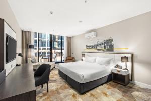 a hotel room with a bed and a television at Peppers Docklands in Melbourne +48 photos