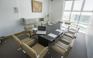 a conference room with a table and chairs and a laptop at Flat melhor localização Brasilia Biarritz Long Stay in Brasilia +33 photos