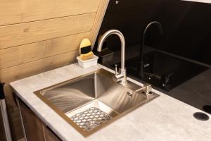 a kitchen sink with two faucets on a counter at Grehit House in Kozmacz +53 photos